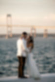 bride and groom in front of newport bridge